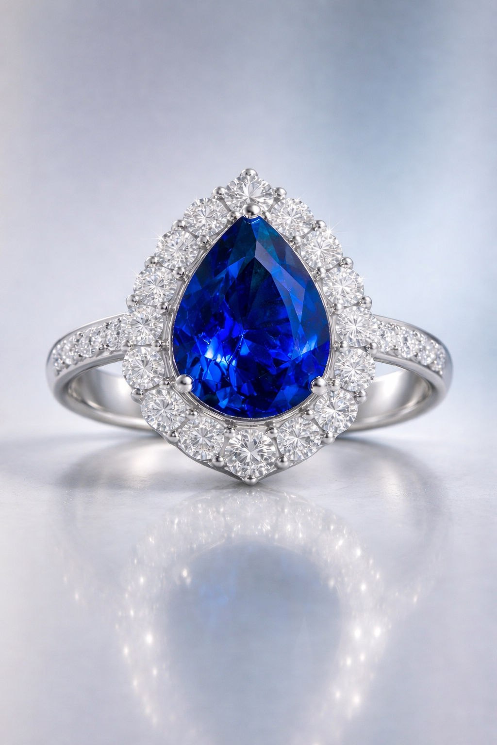 sapphire diamond ring featuring natural blue pear cut sapphire surrounded by brilliant diamond halo white gold