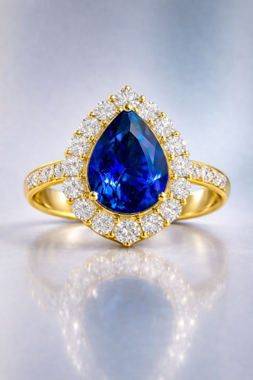 sapphire diamond ring featuring natural blue pear cut sapphire surrounded by brilliant diamond halo yellow gold